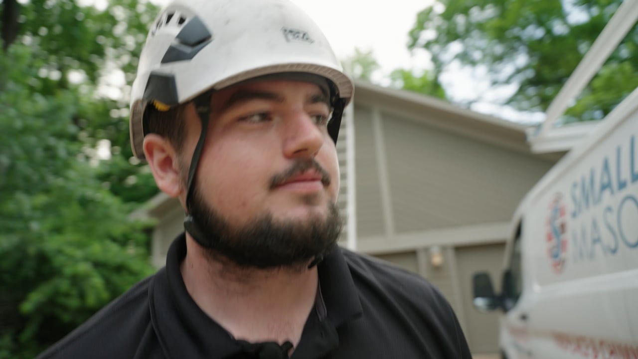 Smalling Masonry technician in a helmet beside the company van